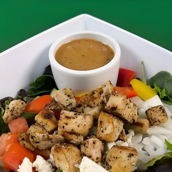 Fit Factory Grill's healthy salad with grilled chicken, feta, tomatoes, and dressing.
