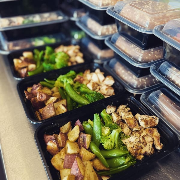 Rows of Fit Factory Grill healthy meal prep containers with chicken, potatoes, and green vegetables.