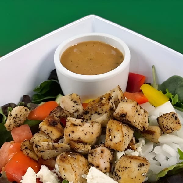 Fit Factory Grill's healthy salad with grilled chicken, tomatoes, onions, feta, and dressing.